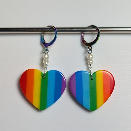 Rainbow heart-shaped earrings on a white background