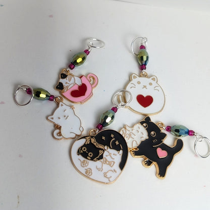 Cat-themed stitch markers with colorful beads on a white background
