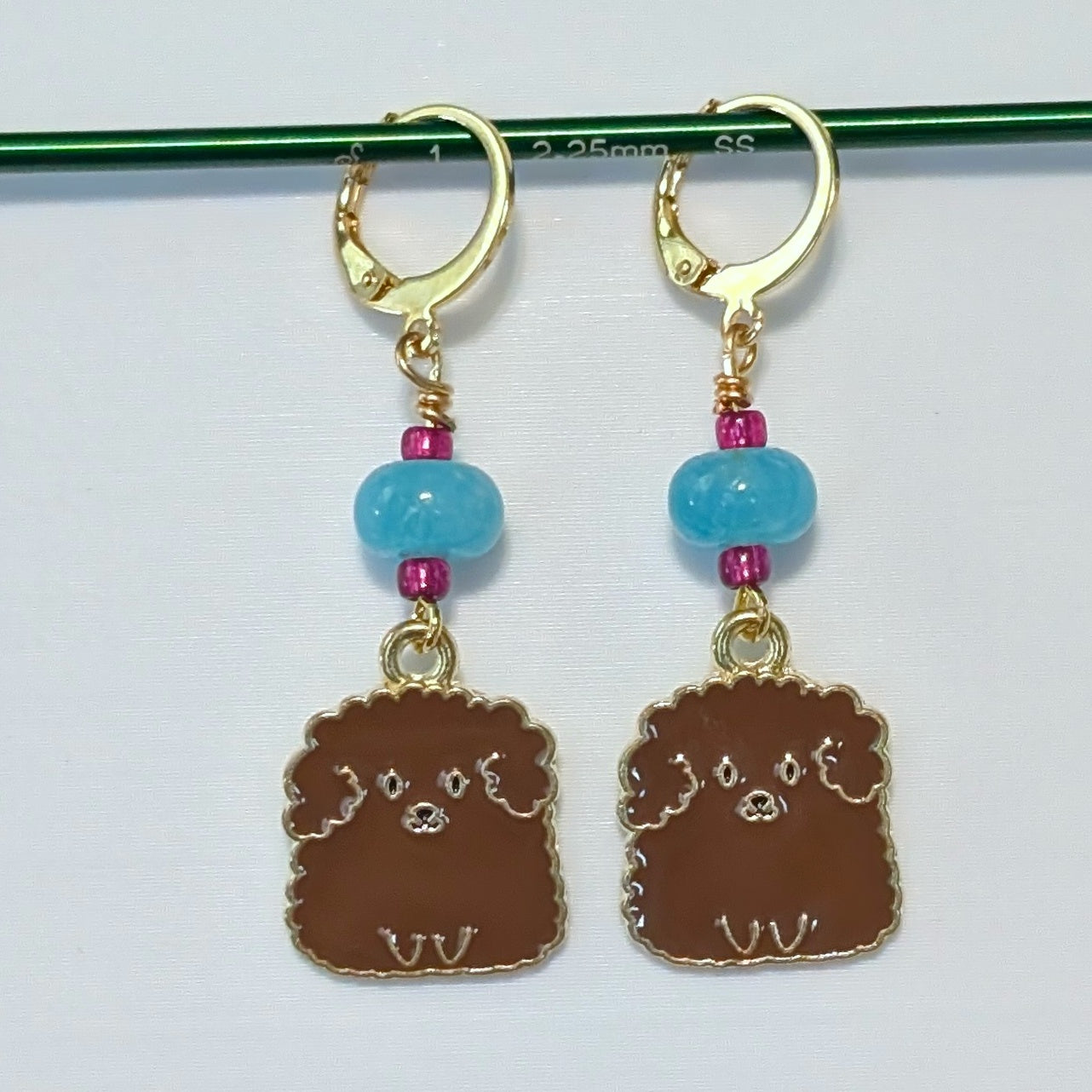 Dog-shaped earrings with blue beads on a white background