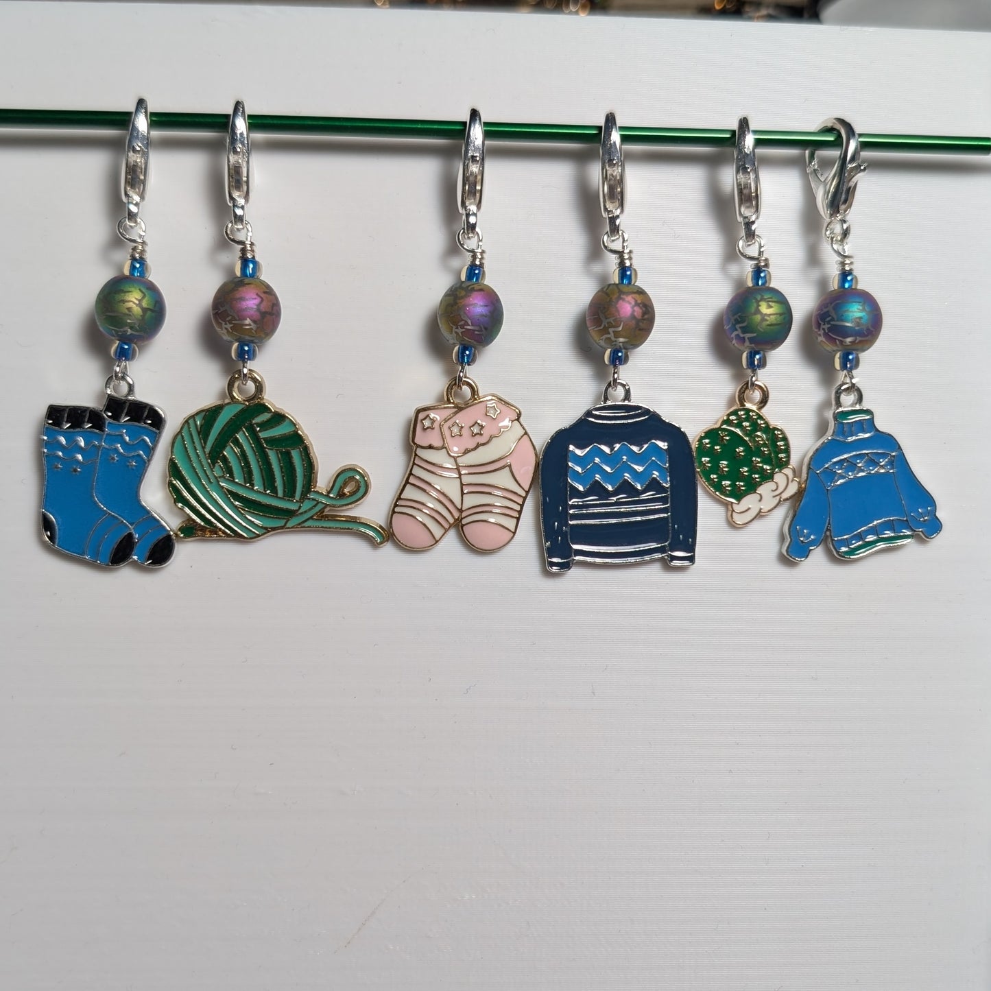 Set of colorful knitting stitch markers on a white background
