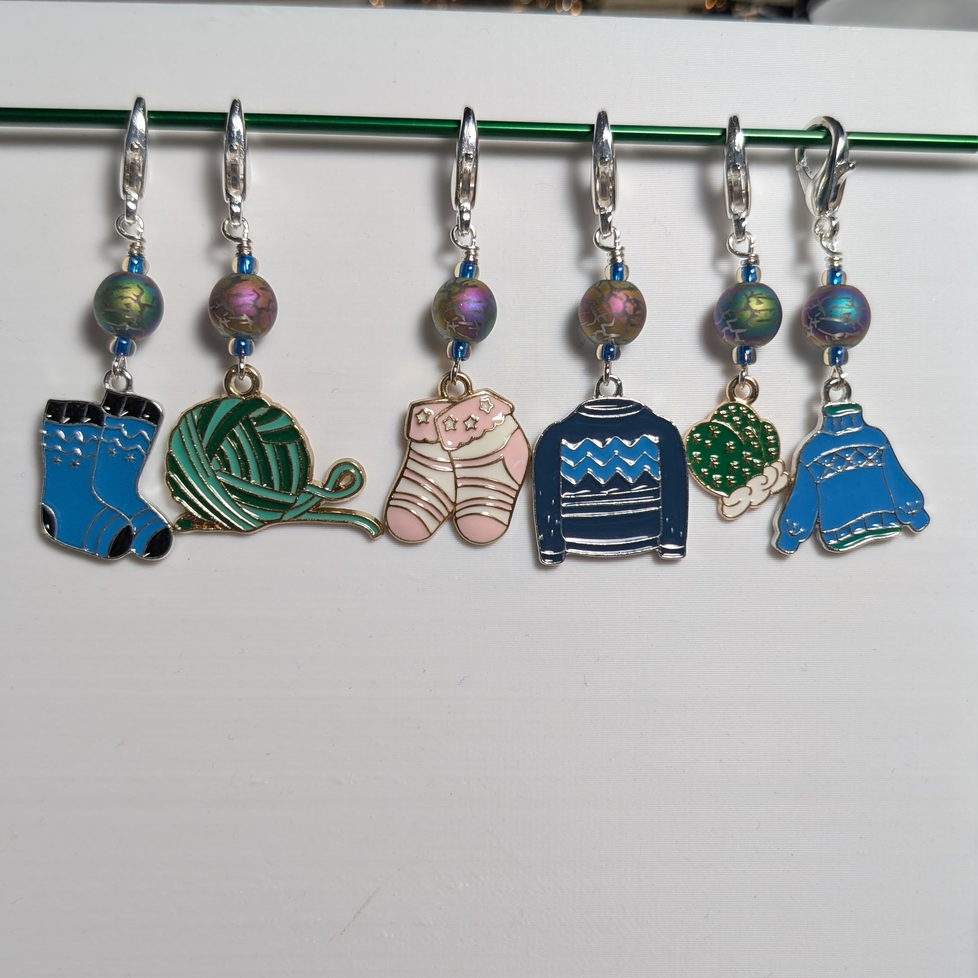 Set of colorful knitting stitch markers on a white background