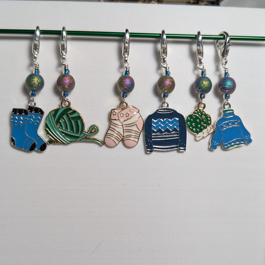 Set of colorful knitting stitch markers on a white background