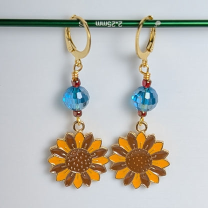 Sunflower earrings with blue beads on a white background